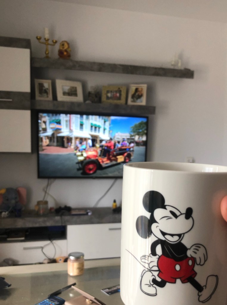 Drinking tea from Mickey mug watching the Imagineering story