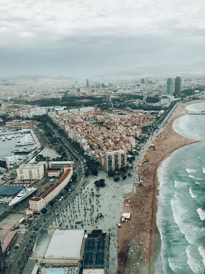 must visit cities airplane view of raining barcelona