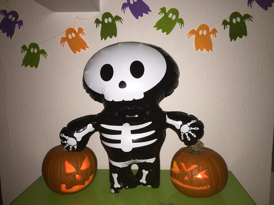 carved pumpkins with a skeleton inflatable and ghosts banner