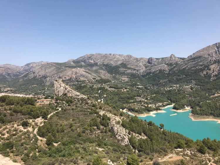beautiful photo of the mountains and blue water at guadalest village near benidorm