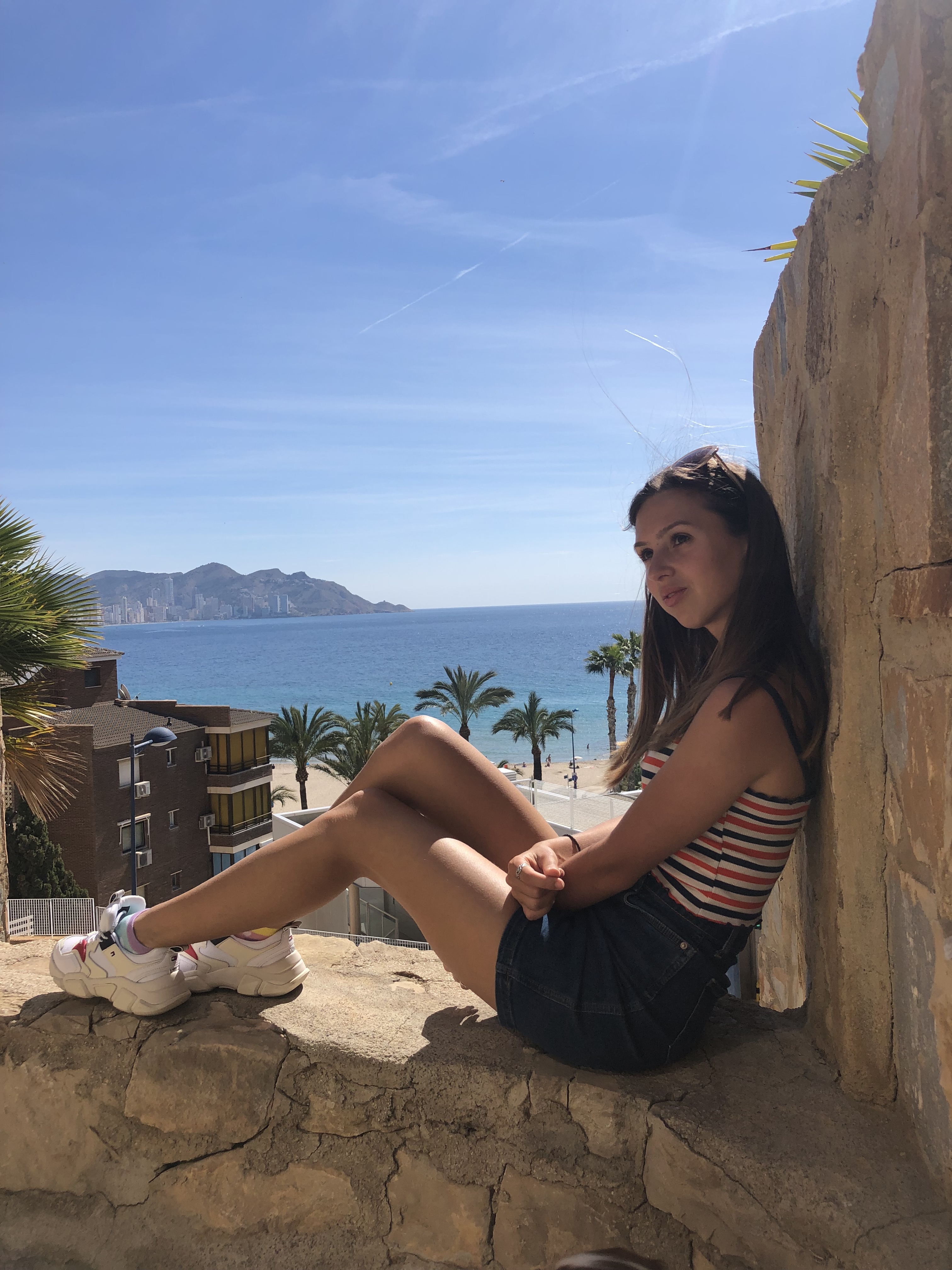 overlooking benidorm girl sitting on cliff