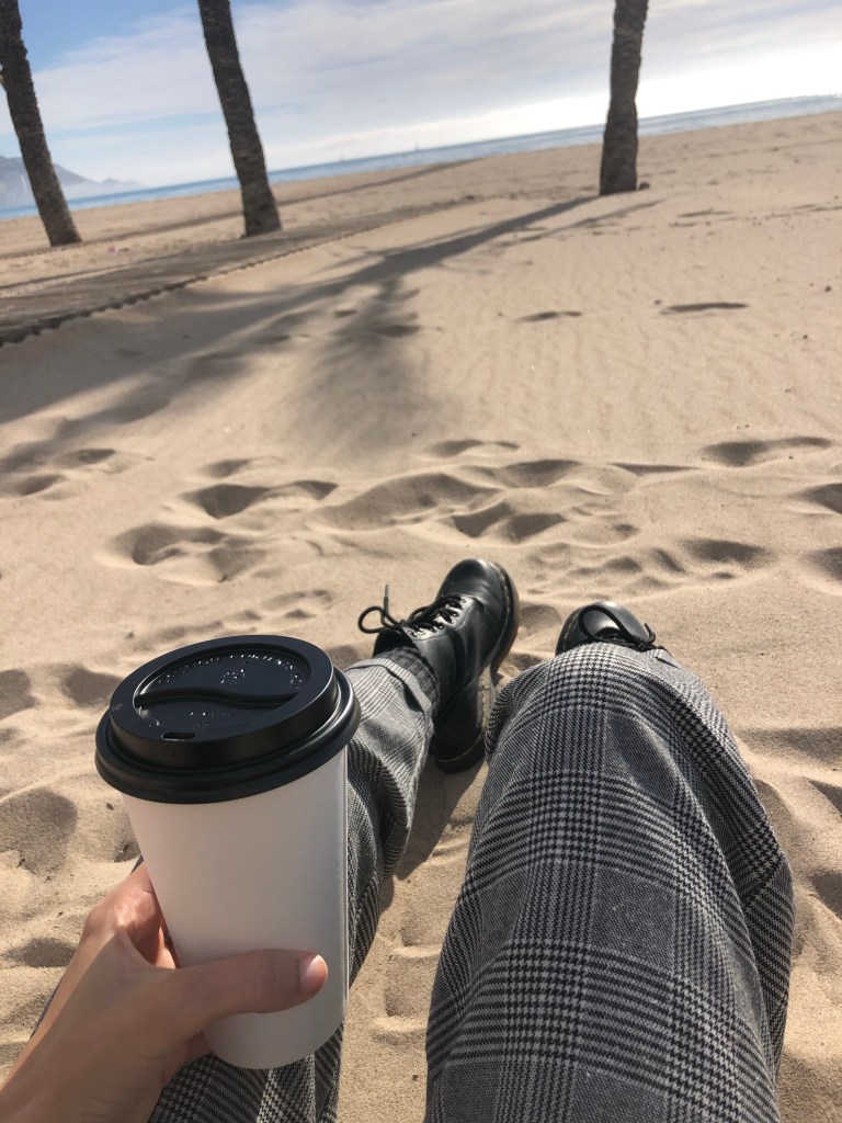 Sitting on bench holding coffee