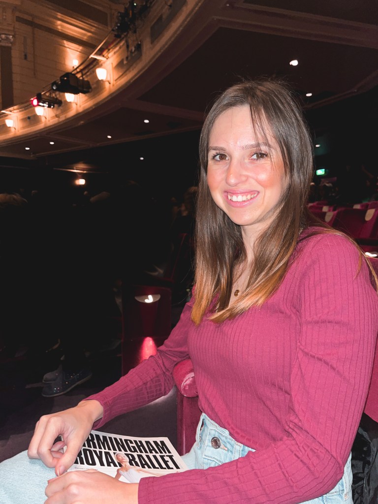 lauren sitting in the birmingham hippodrome holding the swan lake programme