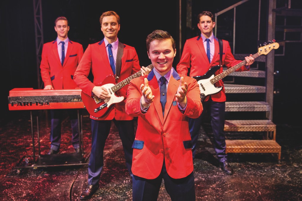 Left to right Blair Gibson Dalton Wood Ryan Heenan Christopher short in Jersey boys wearing red suits with blue trousers one playing the keyboard two play guitar￼