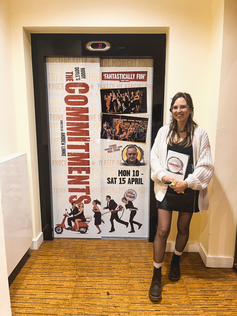 lauren holding the commitments programme infront of the commitments on the elevator at royal and derngate Northampton