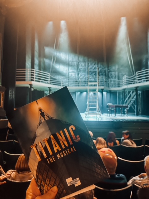 titanic programme held up in front of the titanic set