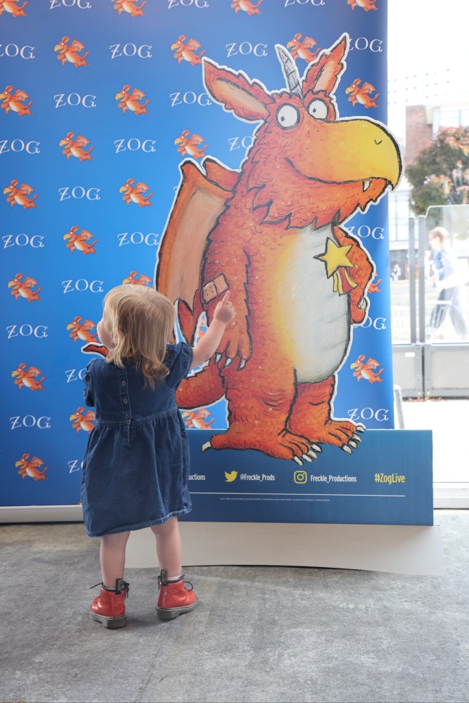young child admiring zog marketing material